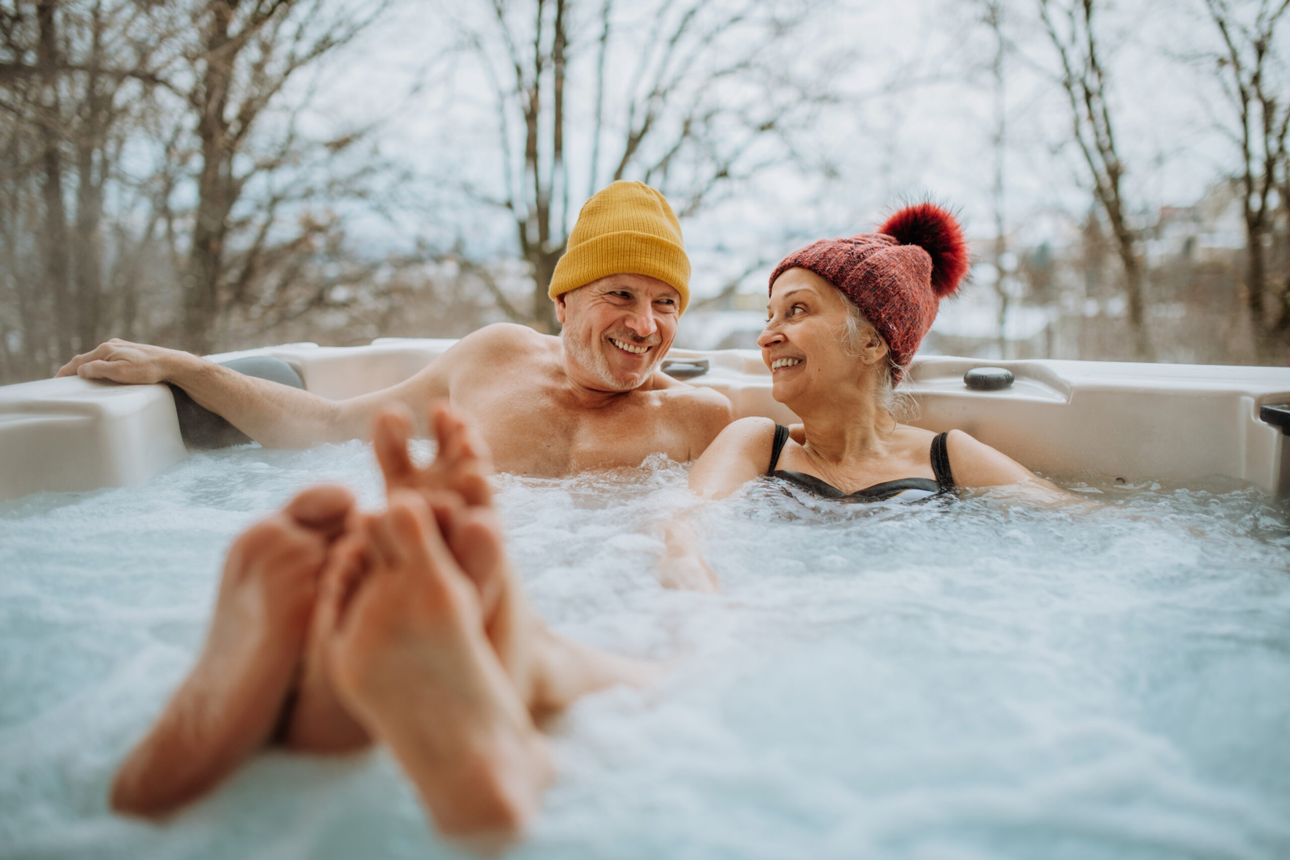 Couple souriant dans un jacuzzi en plein air.